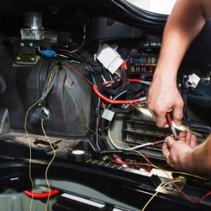 An auto electrician in the Darwin workshop working on a vehicle